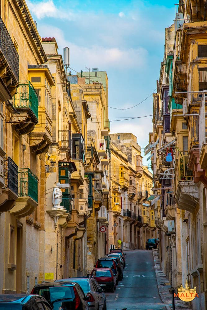 A street with traditional Maltese balconies and a niche in Senglea.