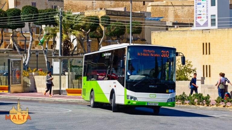 A public bus in Gozo with the Citadel in the background.